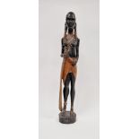 Carved wooden figure of an African girl with beaded decoration to her ankles and chest, 62cm high