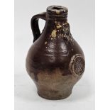 Small brown stoneware bellarmine, probably 17th century, moulded with mask above a rose medallion,