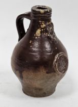 Small brown stoneware bellarmine, probably 17th century, moulded with mask above a rose medallion,