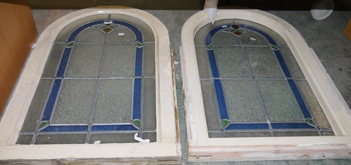 Pair round arch stained glass windows in blue, green and ochre, 91cm x 59cm including painted wood