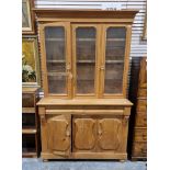 Pine kitchen dresser, the top section with glazed panels and two cupboard doors opening to reveal