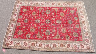 Large Eastern wool carpet of Persian-style with red field, having allover scrolling flowers and