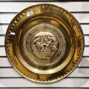19th century continental embossed brass circular charger, the central boss decorated with stylised