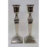 Pair of Covent Garden Trading Company white metal urn-shaped column candlesticks, each surmounting a