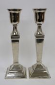 Pair of Covent Garden Trading Company white metal urn-shaped column candlesticks, each surmounting a