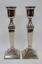 Pair of Covent Garden Trading Company white metal urn-shaped column candlesticks, each surmounting a