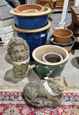 Composite stone lion, a composite stone pig and a selection of terracotta pots, some in blue glaze