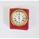 Dunhill gilt metal and leather folding travel clock, the circular gilt dial within red leather