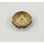 Early 20th century 9ct gold Masonic square and compass pendant in a round glazed mount, 5.1g