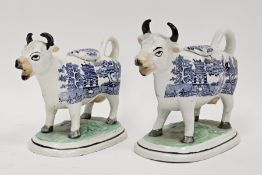 Two 19th century Staffordshire pottery cow creamers with blue transfer willow pattern standing on
