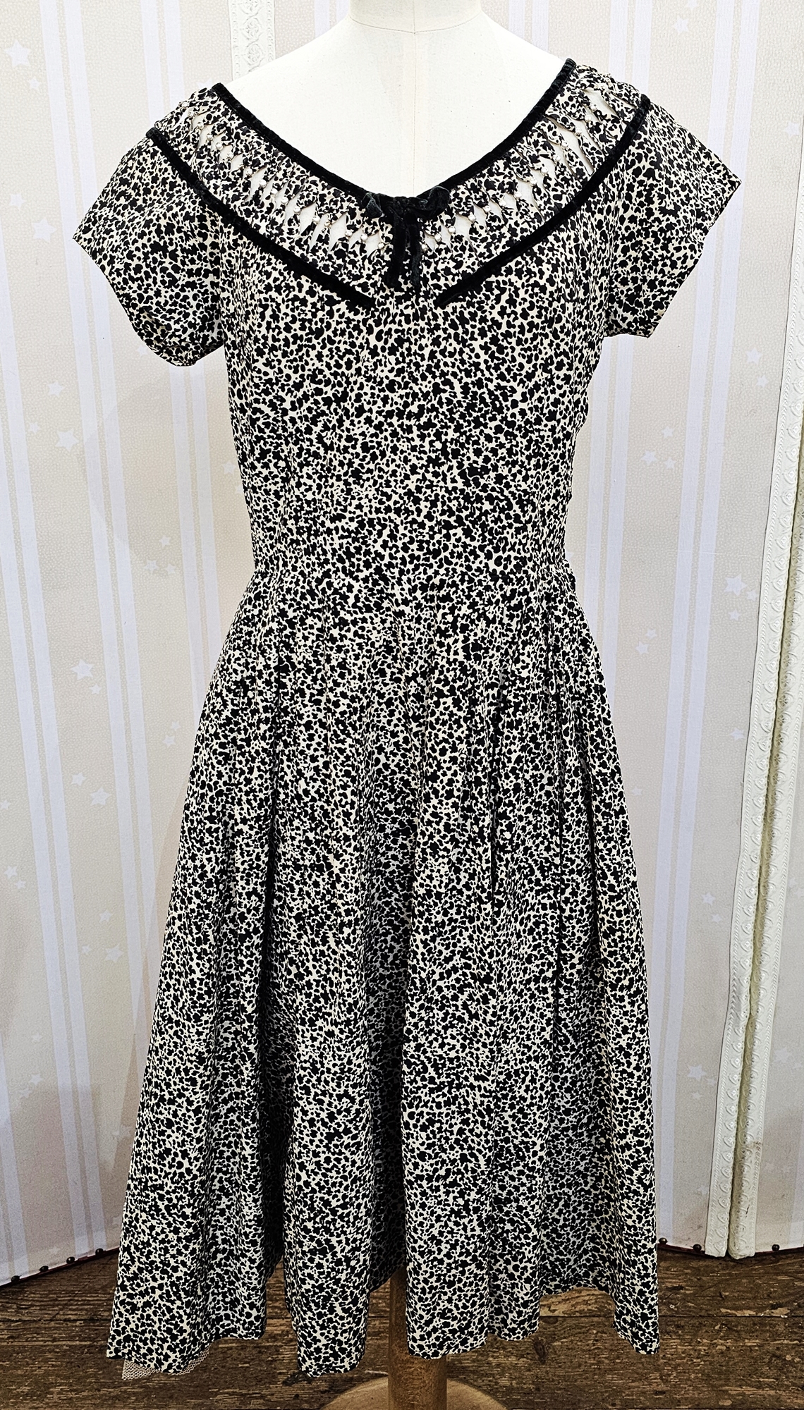 A white and black printed summer dress, with black velvet trim and openwork detailed with faux