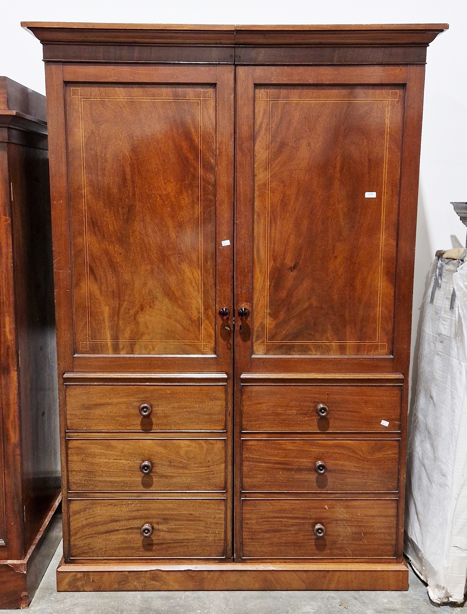 19th century mahogany wardrobe comprising two sections with a moulded cornice, each section with a