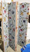 Early 20th century four-fold dressing screen, each section covered in fabric and with woolwork