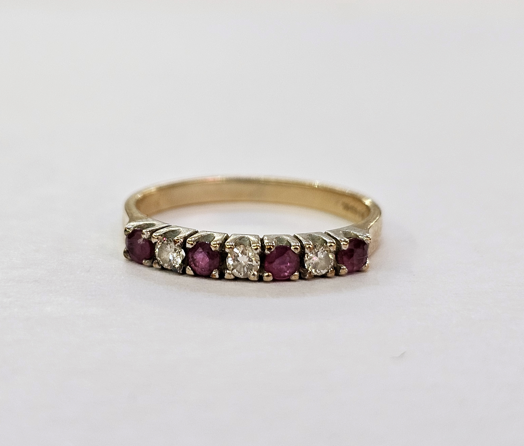 9ct gold seven-stone diamond and ruby ring with alternating brilliant cut diamonds and circular