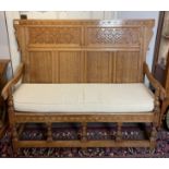 A light oak peg jointed Arts and Crafts movement period settle with cushion 