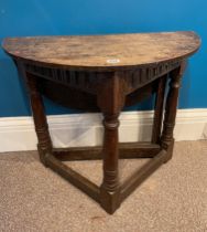 A 17th century oak credence table with a drop leaf side.