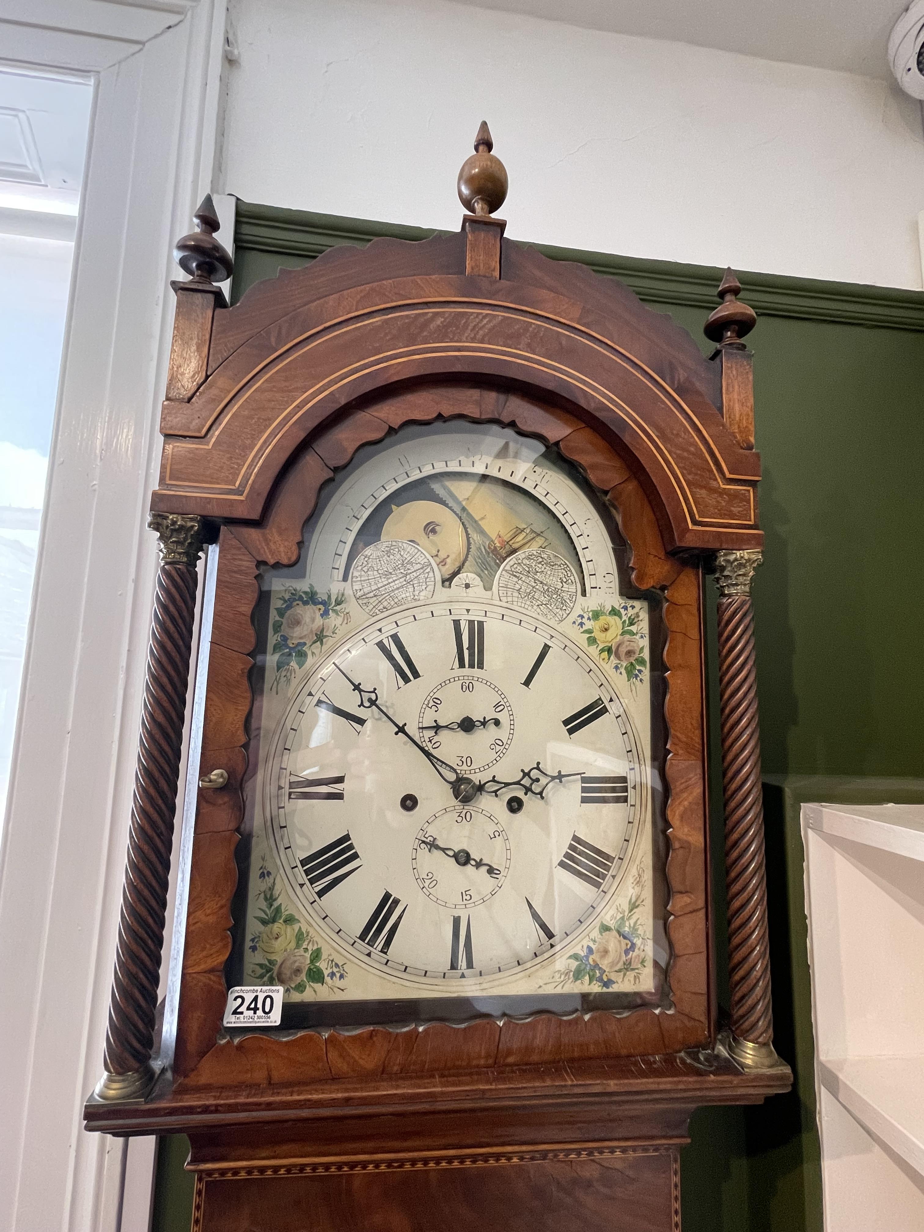 An eight day moon roller longcase clock with painted world maps and ship scene in an inlaid case.