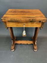A William IV rosewood swivel-top games table, on trestle style supports and bun feet
