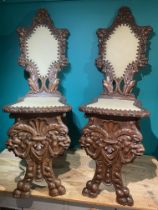 A Pair Of Continental Sgabello Chairs, Heavily Carved With Grotesques And Cherubs
