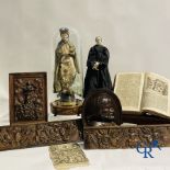 A lot with various antique wood sculptures and an antique book on a reading table.