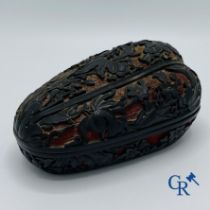 Asian Art: A finely carved Chinese lid box in black lacquer on a red background.