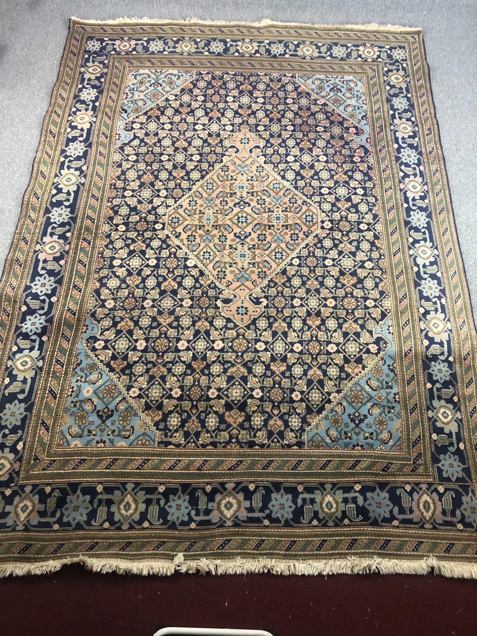 An Ardebil carpet with central lozenge medallion and flowerhead design across the midnight field