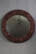 A round mirror decorated with a carved floral frame. Dia.95 cm.