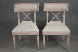 A pair of 19th century painted dining chairs in the Gustavian style.