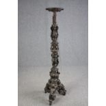A large bronze 19th century Classical style figural torchere decorated with putti holding the