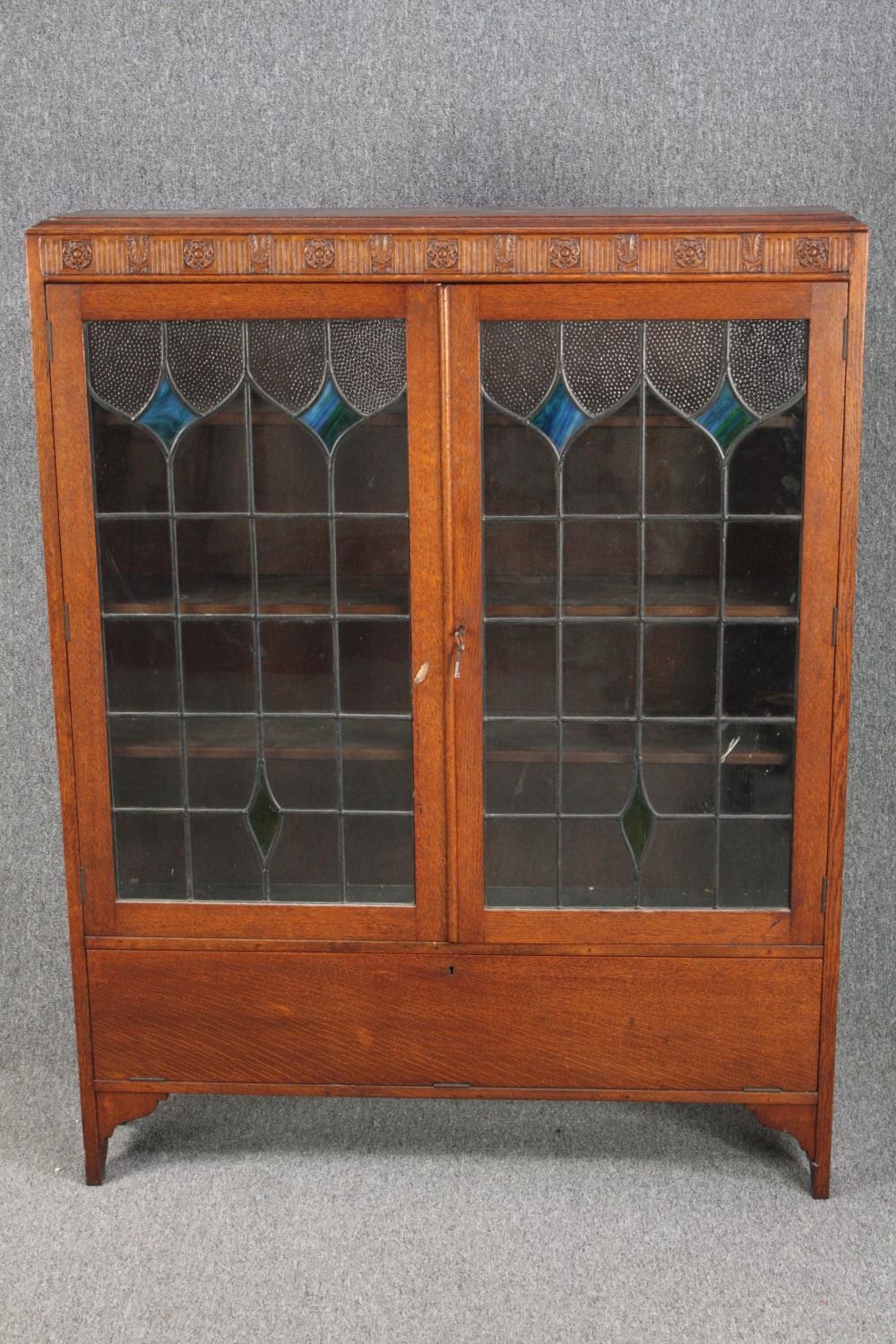 Bookcase, mid century oak with leaded and coloured glass doors. H.137 W.107 D.24cm.