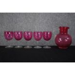 A set of Victorian Cranberry glasses made up of five wine glasses and matching jug. H.16 cm. (