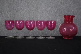 A set of Victorian Cranberry glasses made up of five wine glasses and matching jug. H.16 cm. (