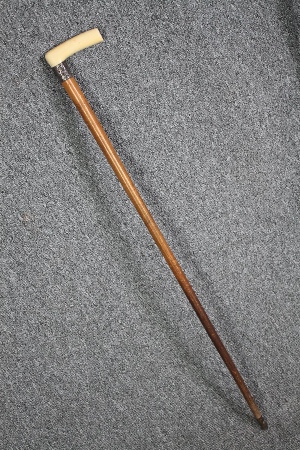 A pair of walking canes. The smaller one with a bone and silver handle the other, German and - Image 2 of 7