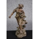 A metal figure. Probably early twentieth century. A women sowing seeds. With some damage to the