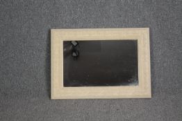 A wall mirror in a painted carved frame. H.50 W.70cm.