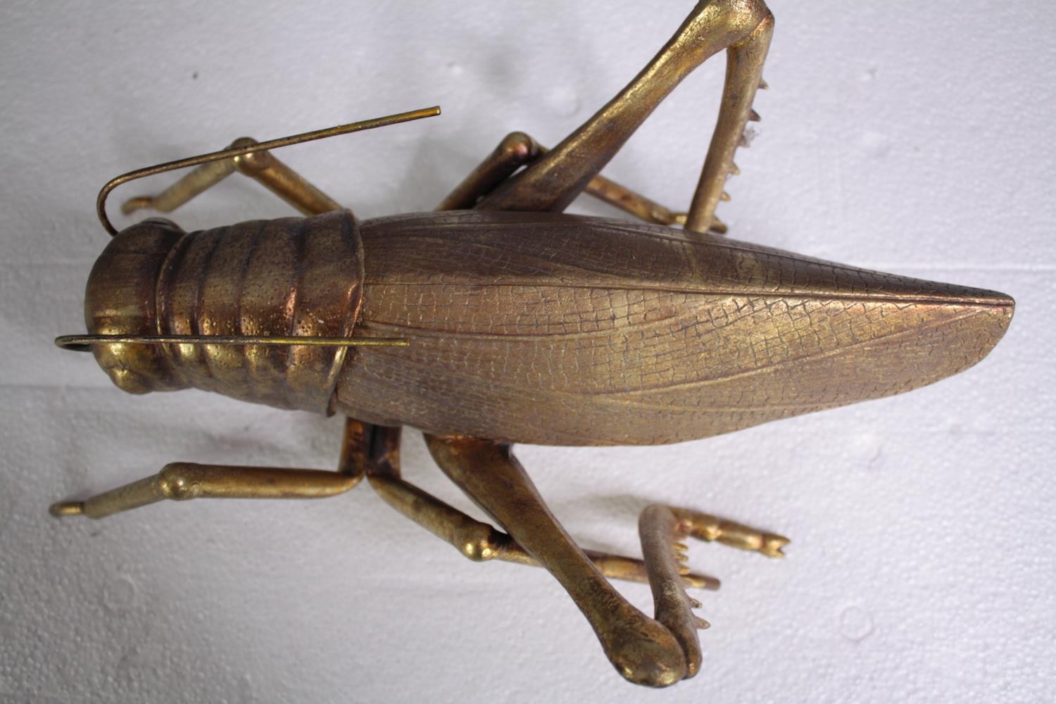 A decorative grasshopper, gold lacquered. H.5 W.39cm. - Image 5 of 5