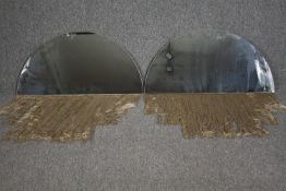 A pair of arched contemporary mirrors with tassle fringed bases. H.40 W.80cm. (each)