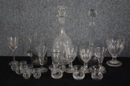 A mixed assortment of Victorian glass including a jug, two decanters, shot glasses, wine glasses