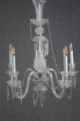 A crystal chandelier with four branches of lights. H.83cm. (In need of some repair).