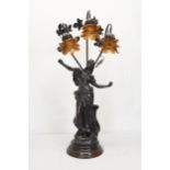 A 20th century spelter classical figural three branch table lamp, the floral shades of moulded amber