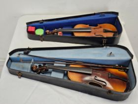 Two old cased violins.