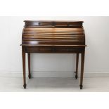 A Georgian style mahogany cylinder top desk with tambour shutter enclosing a fitted interior on