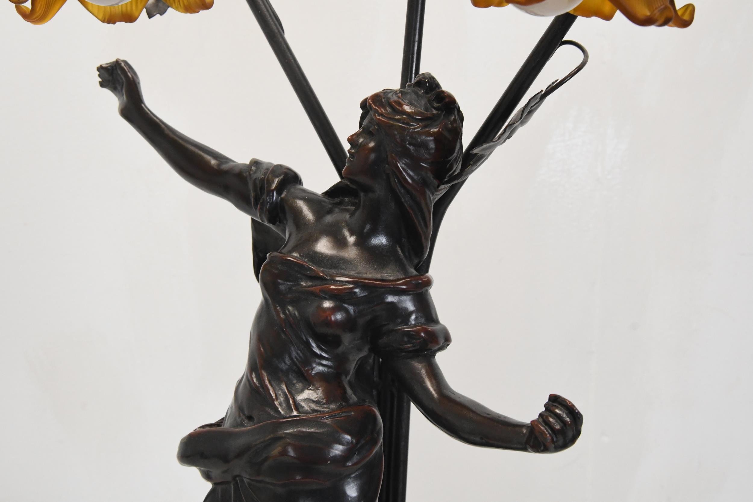 A 20th century spelter classical figural three branch table lamp, the floral shades of moulded amber - Image 4 of 5
