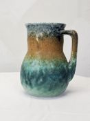 A Ruskin jug glazed in bands of blue, ochre and green, stamped to base. H.16 W.13 D.13cm.