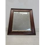 A vintage oak framed mirror with bevelled plate. H.66 W.56cm.