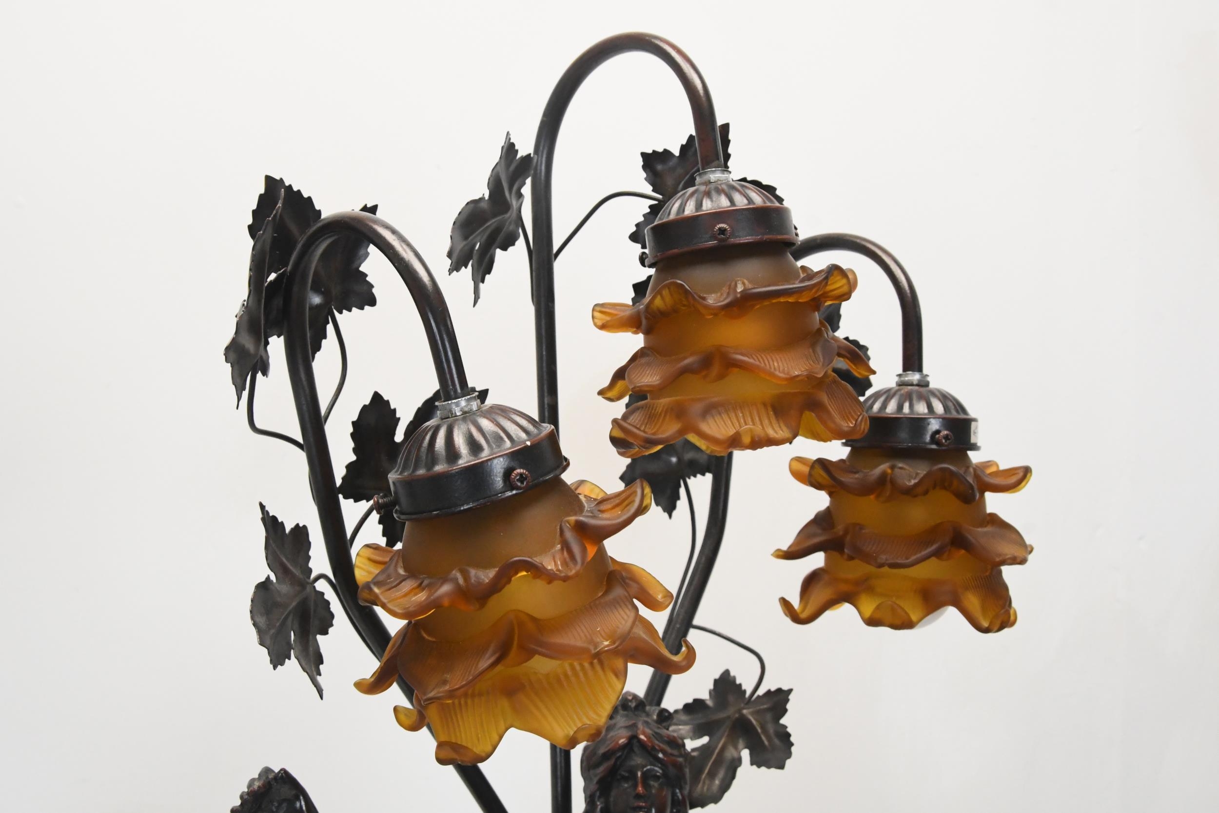 A 20th century spelter classical figural three branch table lamp, the floral shades of moulded amber - Image 5 of 5