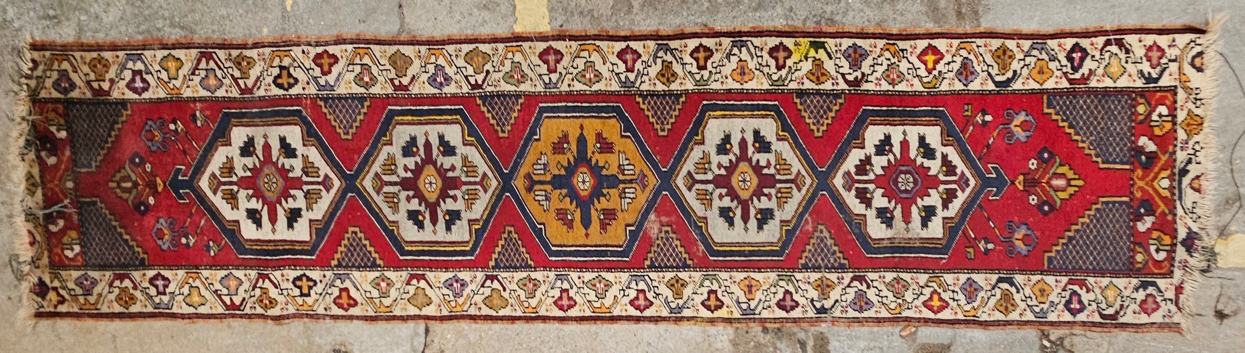 A Talish runner with repeating medallions on a burgundy ground. H.380 W.75cm.