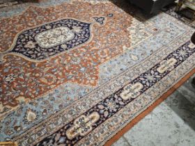 A large Persian style carpet with central medallion on foliate terracotta ground within flowerhead