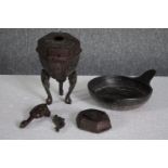 An mixed collection of iron and bronze metalware. Includes a pot on a stand with one leg detached