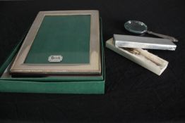 A Harrods sterling silver photo frame, a silver handled magnifying glass and collection of miniature